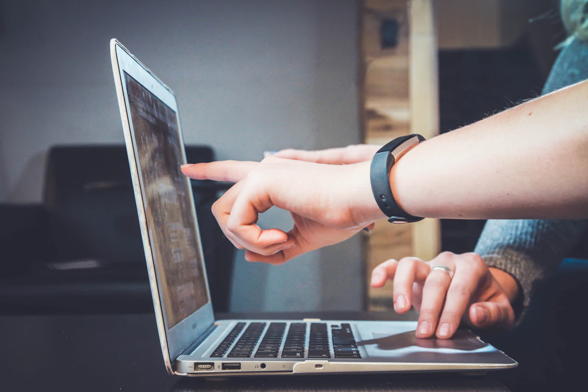 Two people reviewing a website together on a laptop screen