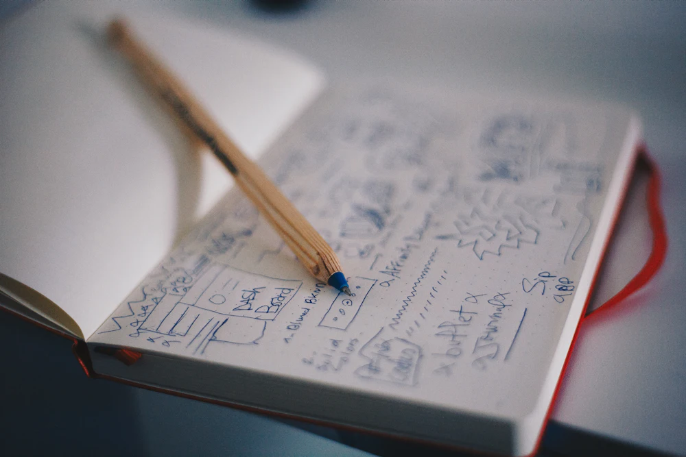 Notebook with hand-drawn website wireframe sketches